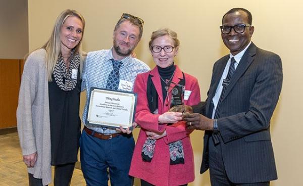 Provost Nakuma presenting Award to Dennis DeBay, Lisa Forbes, and Pam Laird